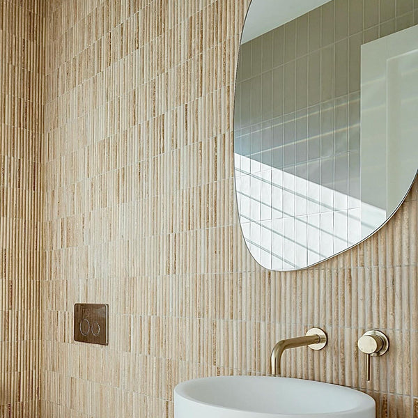 Travertine bamboo mosaic feature wall in a warm-toned bathroom