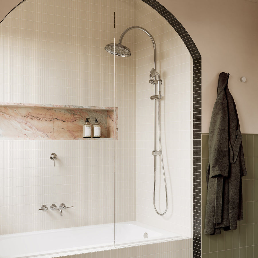 Arched shower recess with a chrome rail shower, overhead rose and a stone niche