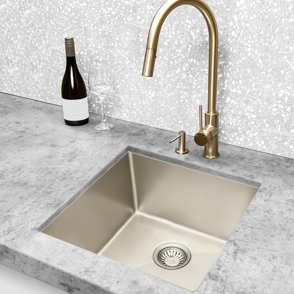Undermount kitchen sink with brushed brass gooseneck mixer on a concrete-look benchtop